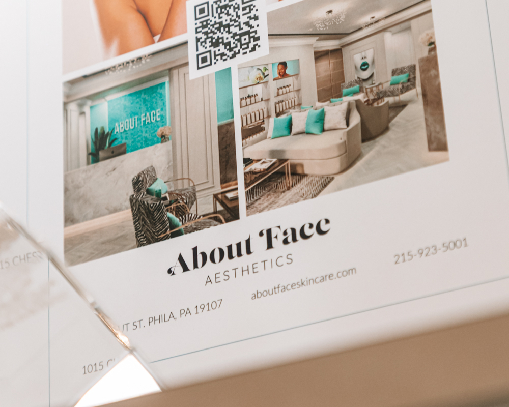 Un gros plan d'une brochure About Face Aesthetics, mettant en avant leurs traitements d'induction de collagène à Rittenhouse Square.