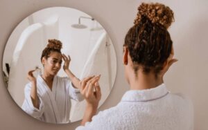A woman applying face cream during an evening skincare routine.